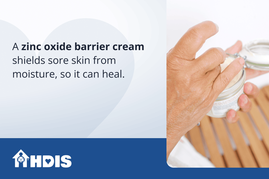 A hand holding a small box with cream